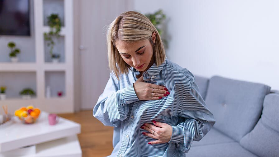 mulher a verificar os seios devido a dor ou inchaço