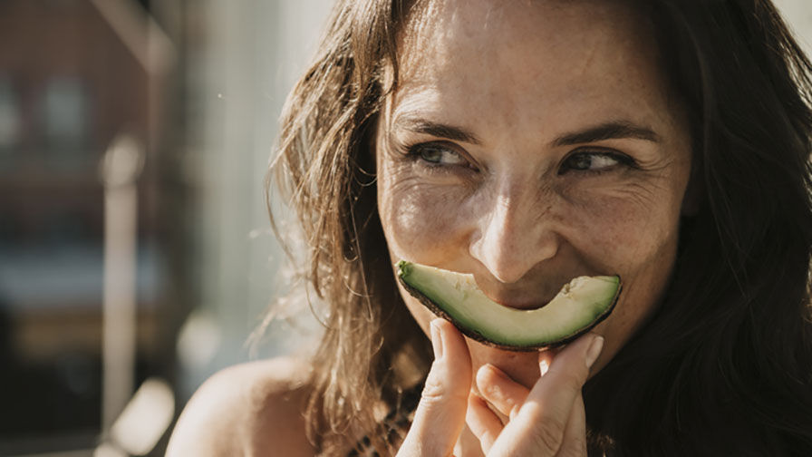Mulher na menopausa a comer abacate