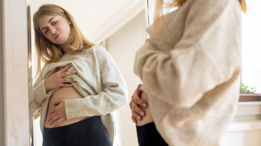 mulher com inchaço abdominal durante a menstruação