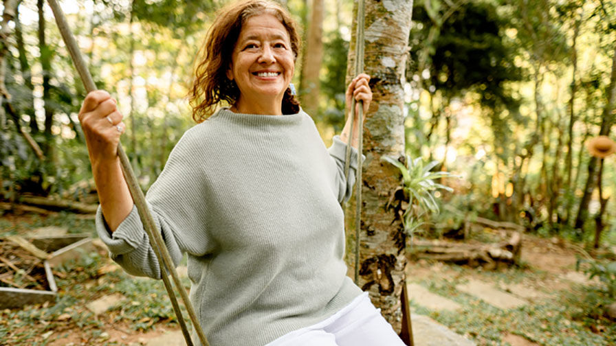 Mulher sentada num baloiço ao ar livre, representando serenidade e equilíbrio emocional na menopausa 